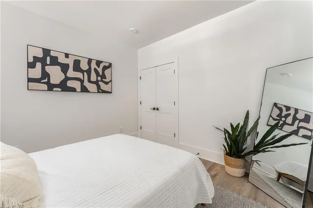 a bedroom with a large bed and potted plant