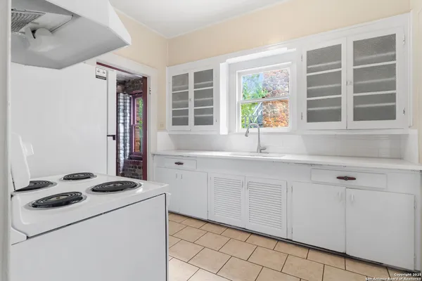 a kitchen with a stove a sink and a window