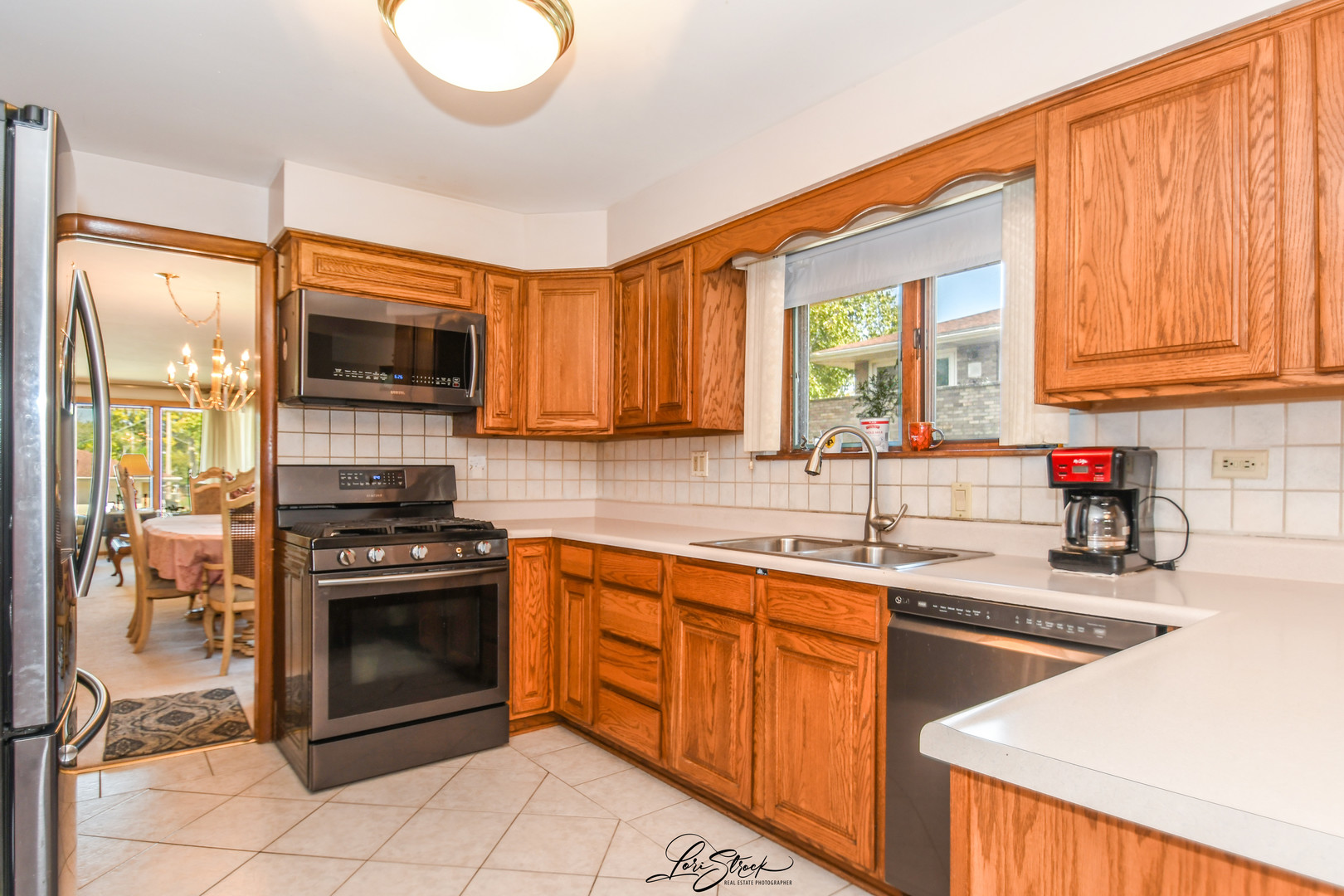3409 173rd Place Lansing, IL 60438 - Photo 11 of 26 a kitchen with stainless steel appliances a stove sink microwave and cabinets