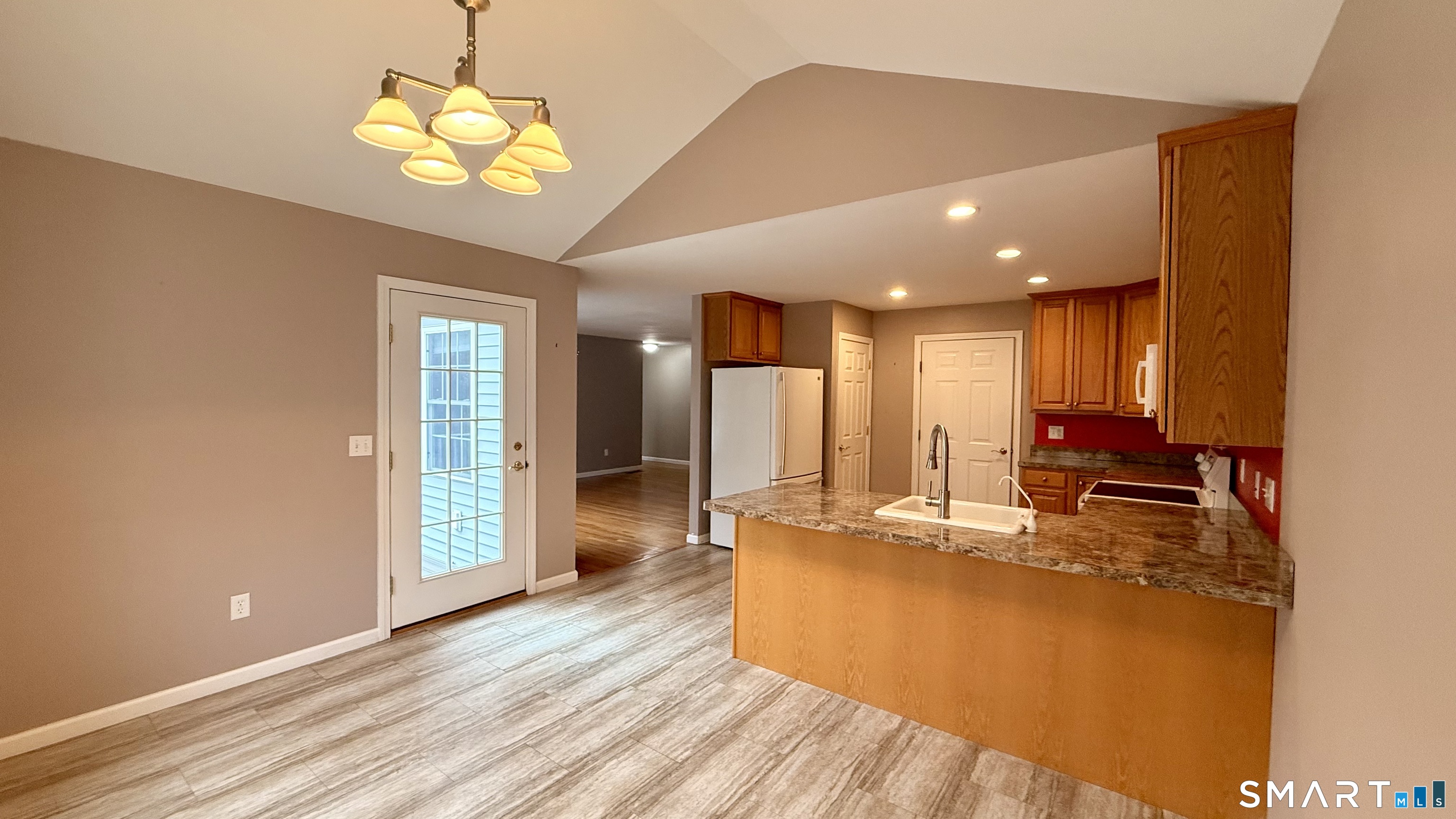 55 Nina's Way, Unit 55 Manchester, CT 06040 - Photo 7 of 25 a view of a dining room with furniture a chandelier and wooden floor
