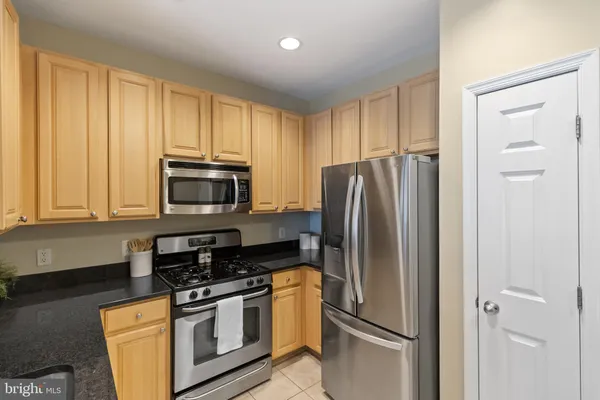 a kitchen with stainless steel appliances granite countertop a refrigerator stove and microwave