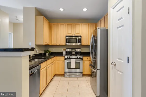 a kitchen with stainless steel appliances granite countertop a refrigerator and a stove top oven
