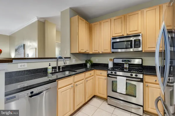 a kitchen with cabinets stainless steel appliances and a sink