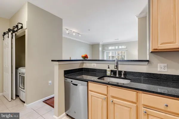 a kitchen with granite countertop a sink and a refrigerator