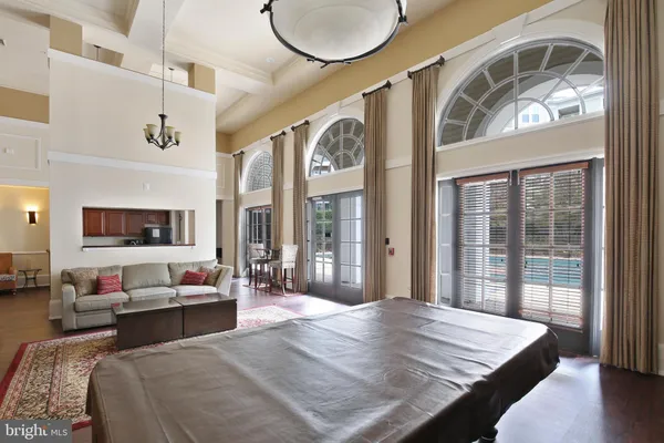 a living room with dining table a rug kitchen view and a large window
