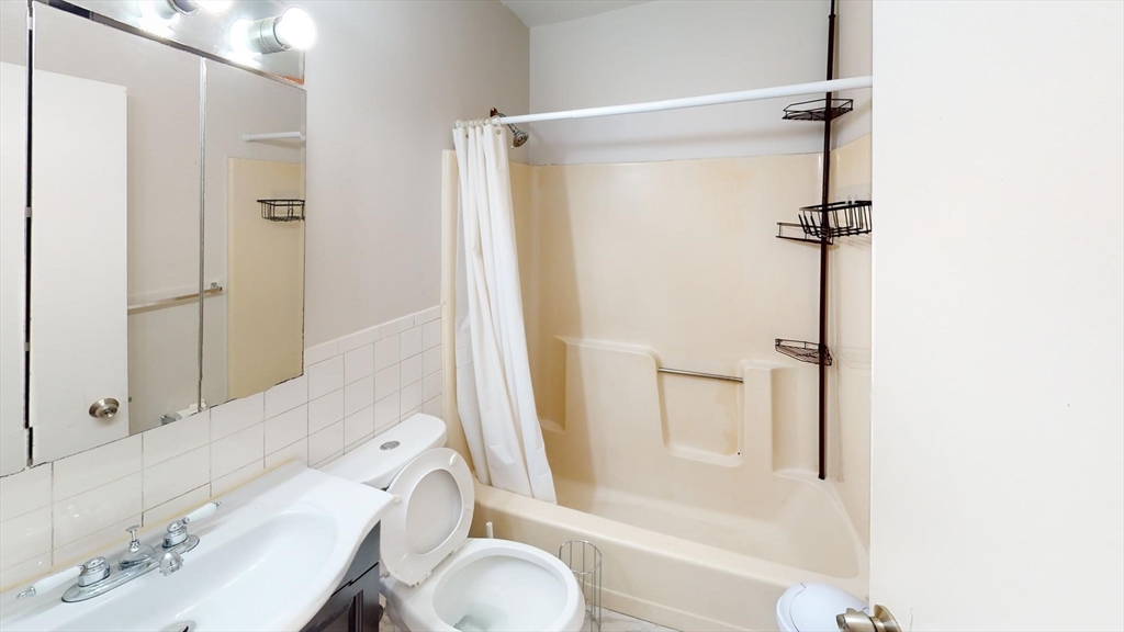 96 Hammond Street, Unit 1 Boston, MA 02120 - Photo 12 of 14 a bathroom with a granite countertop sink toilet and shower