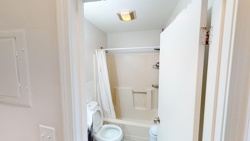 96 Hammond Street, Unit 1 Boston, MA 02120 - Photo 14 of 14 a bathroom with a granite countertop shower and a toilet