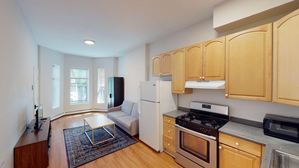 96 Hammond Street, Unit 1 Boston, MA 02120 - Photo 4 of 14 a kitchen with stainless steel appliances granite countertop a stove a sink and a refrigerator