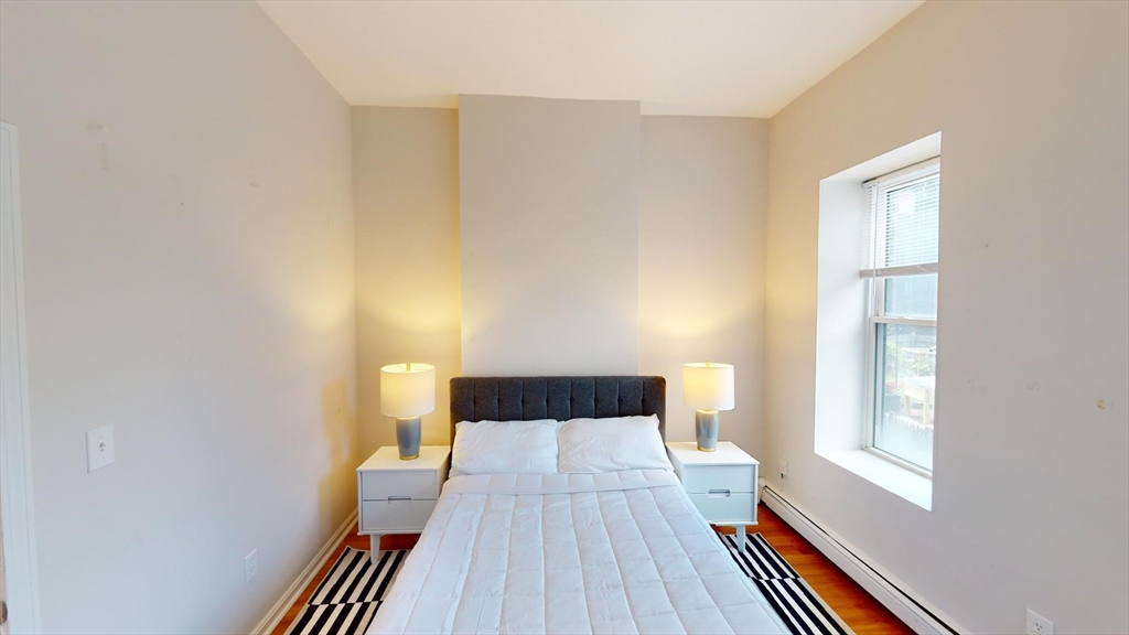 96 Hammond Street, Unit 1 Boston, MA 02120 - Photo 5 of 14 a bedroom with a bed and wooden floor