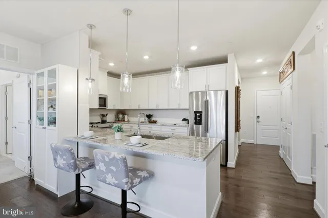 a kitchen with stainless steel appliances kitchen island granite countertop a refrigerator and a stove top oven