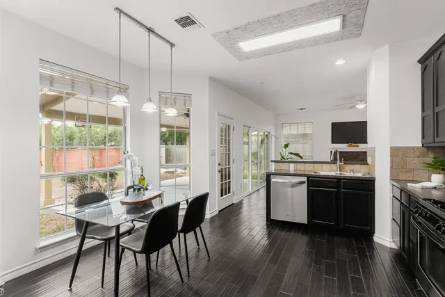 a kitchen with stainless steel appliances granite countertop table chairs stove and sink