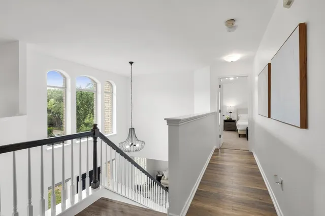a view of a hallway with wooden floor and stairs