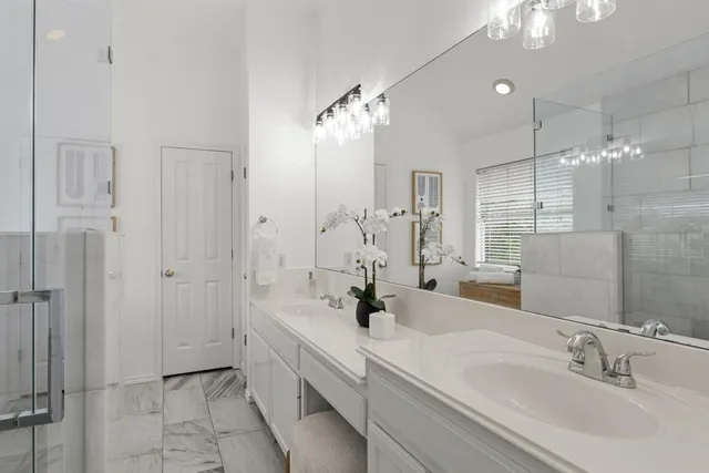 a bathroom with a double vanity sink mirror and shower