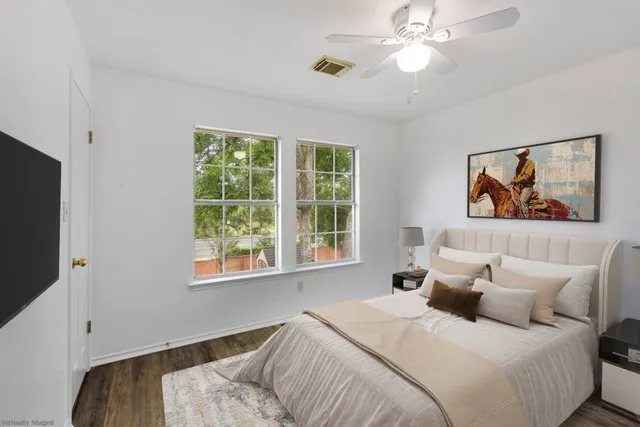 a bedroom with bed tv and window