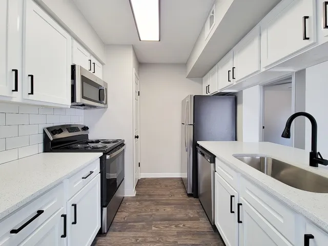 a kitchen with stainless steel appliances granite countertop a sink stove and refrigerator