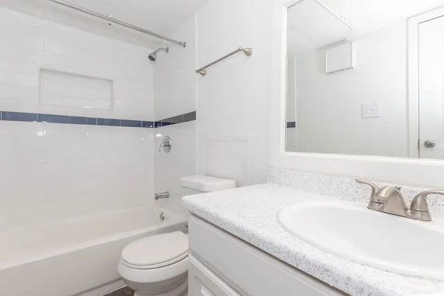 a bathroom with a granite countertop sink toilet and shower