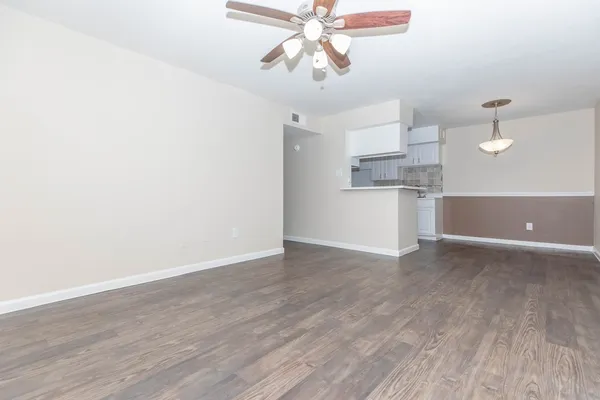 a view of a kitchen with wooden floor and a ceiling fan