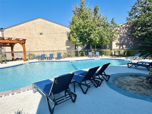 a view of a patio with table and chairs under an umbrella