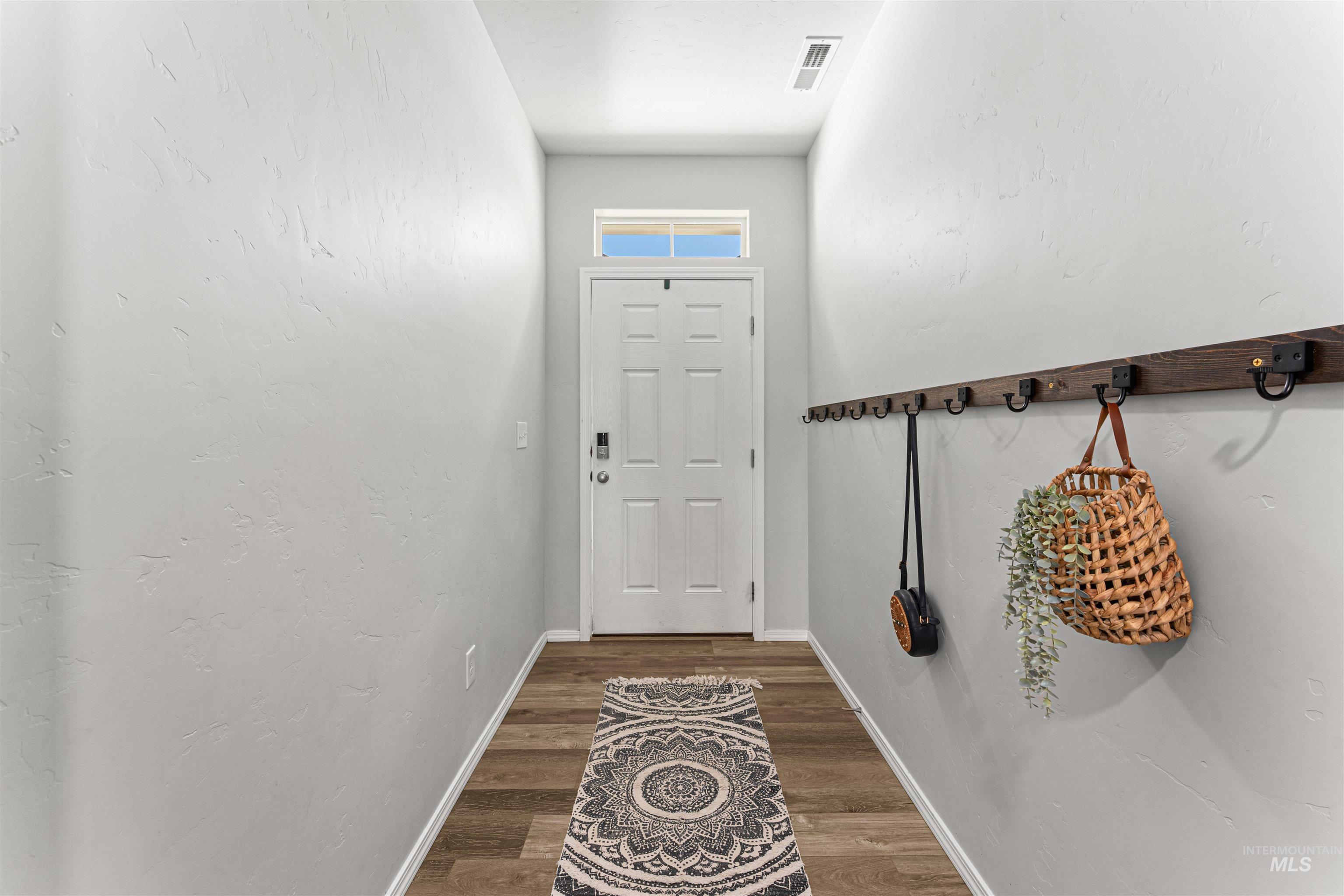 12342 Noreen Street Caldwell, ID 83607 - Photo 11 of 42 Doorway to outside featuring baseboards and wood finished floors