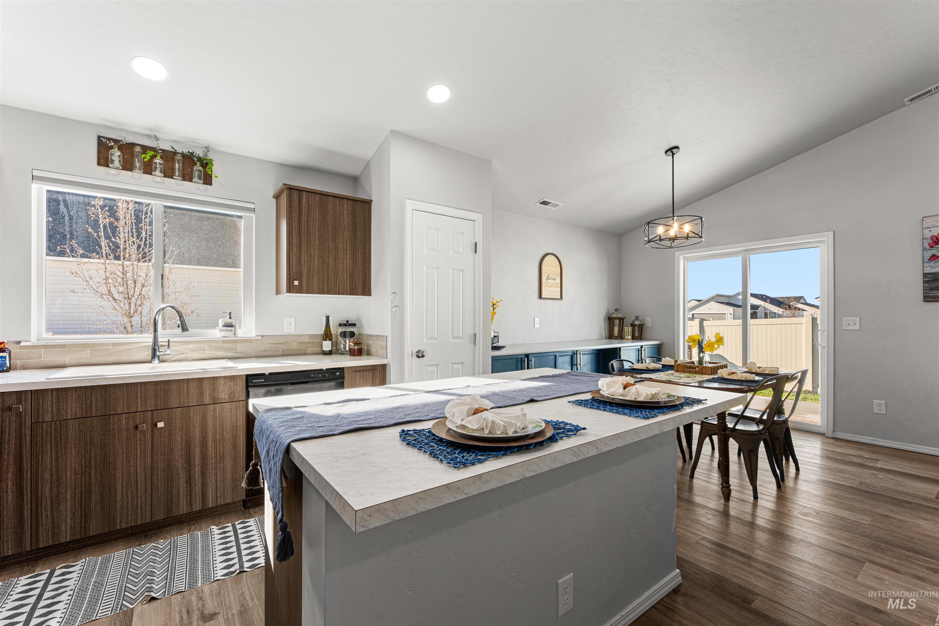 12342 Noreen Street Caldwell, ID 83607 - Photo 19 of 42 Kitchen with light countertops, a kitchen island, dark wood finished floors, decorative light fixtures, and lofted ceiling