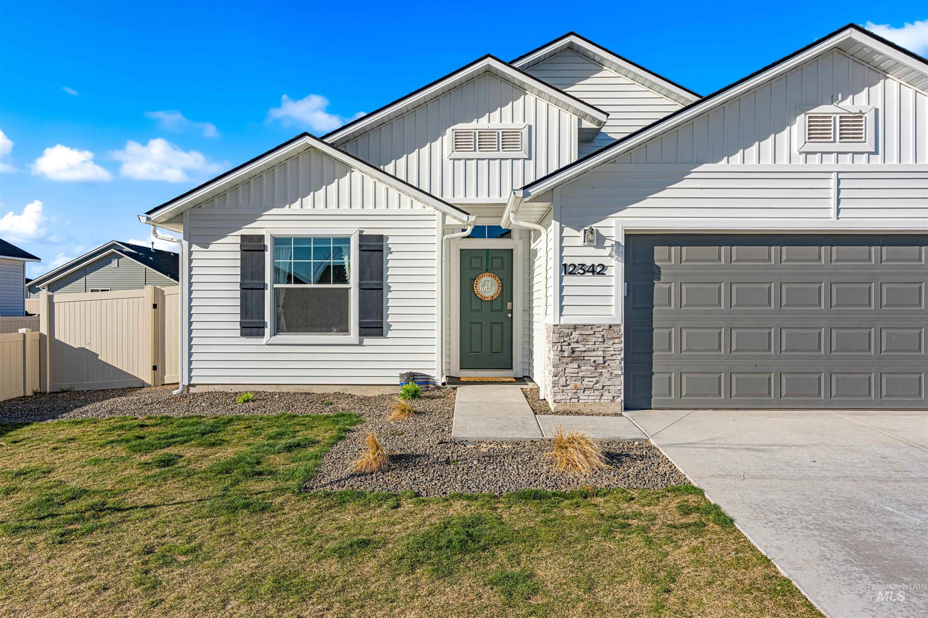12342 Noreen Street Caldwell, ID 83607 - Photo 2 of 42 View of front of house with concrete driveway, board and batten siding, an attached garage, and a gate