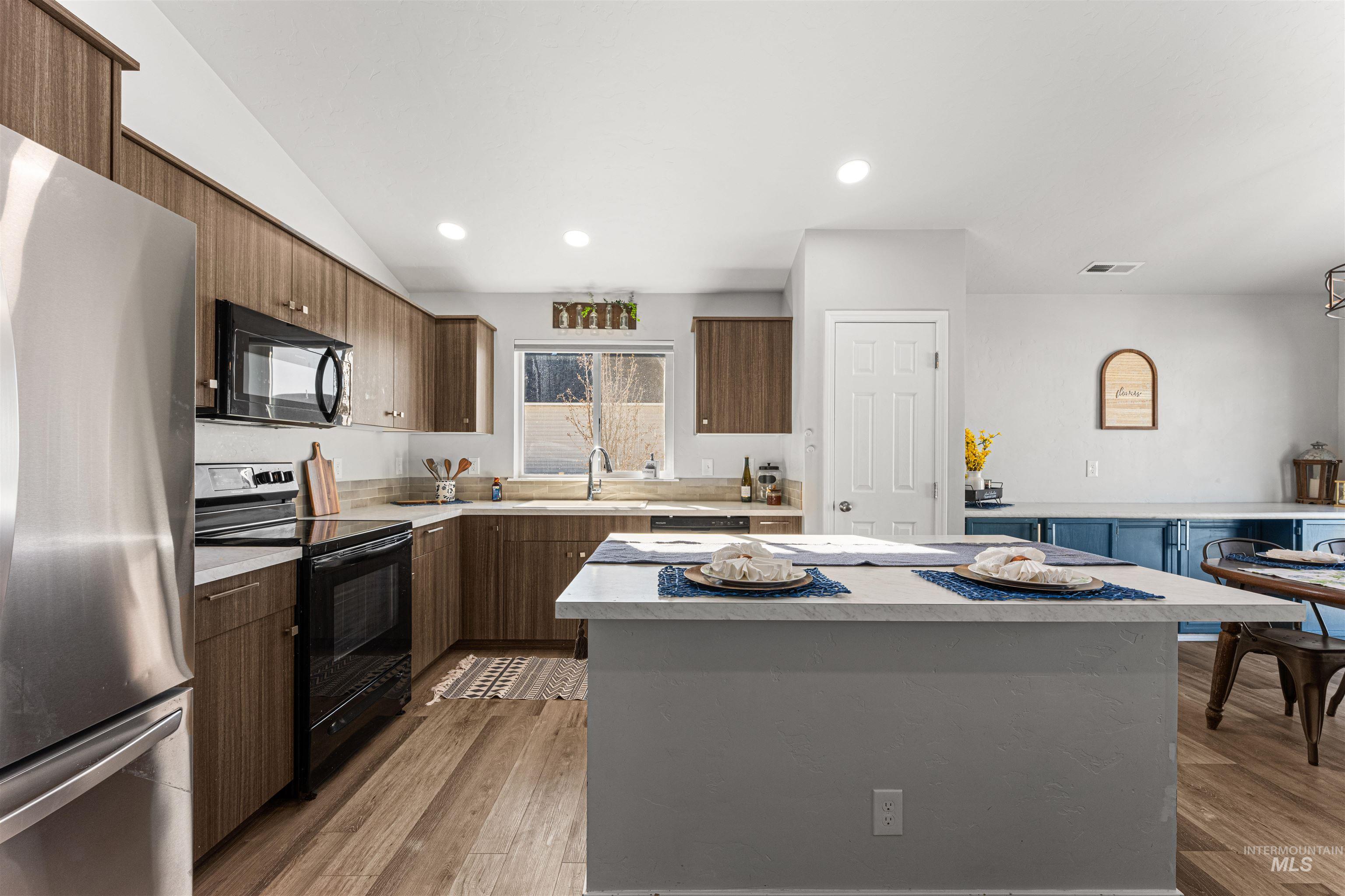 12342 Noreen Street Caldwell, ID 83607 - Photo 20 of 42 Kitchen featuring black appliances, light countertops, a center island, light wood-style flooring, and recessed lighting