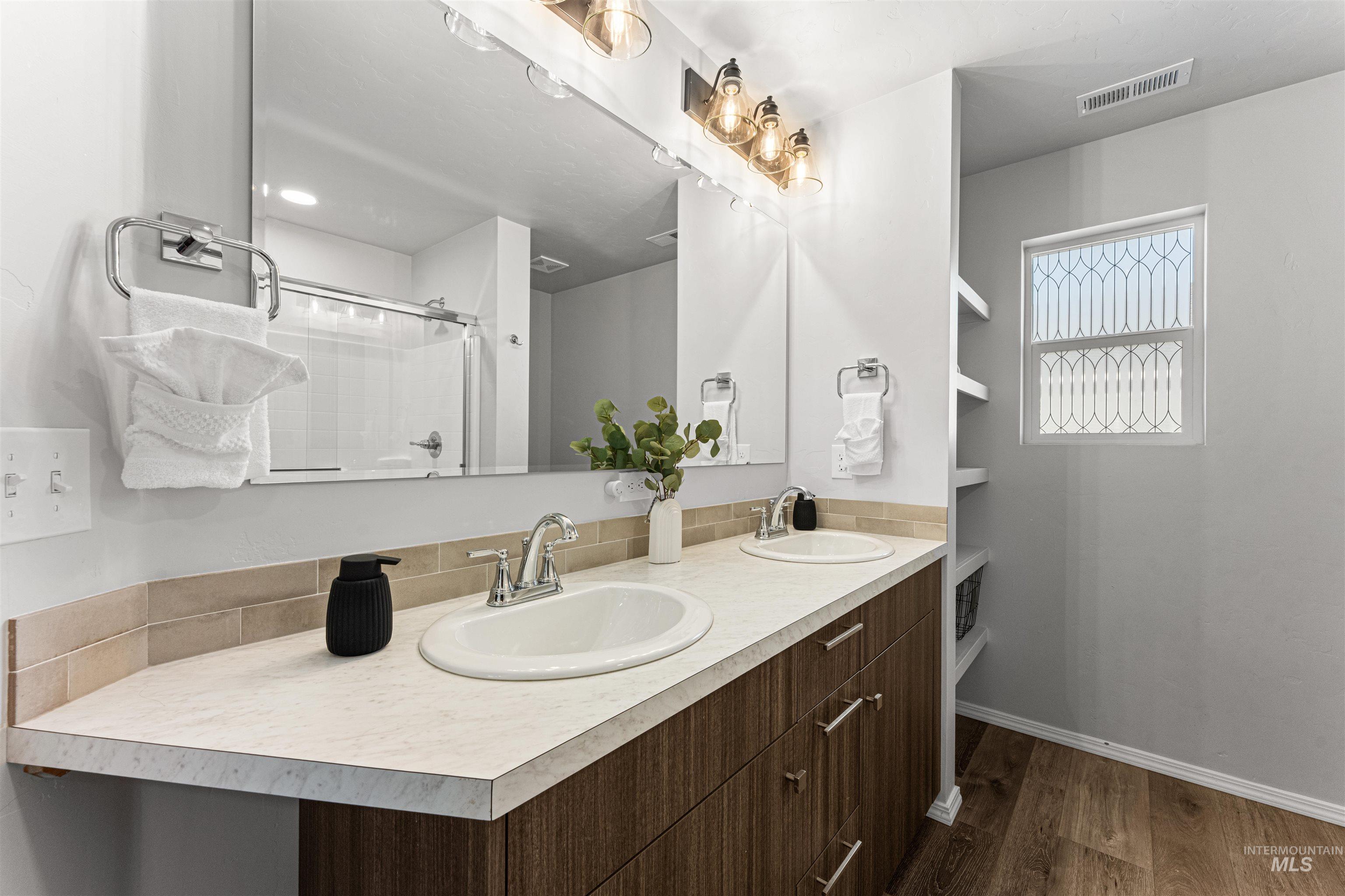 12342 Noreen Street Caldwell, ID 83607 - Photo 27 of 42 Full bath with double vanity, dark wood-style floors, and a shower