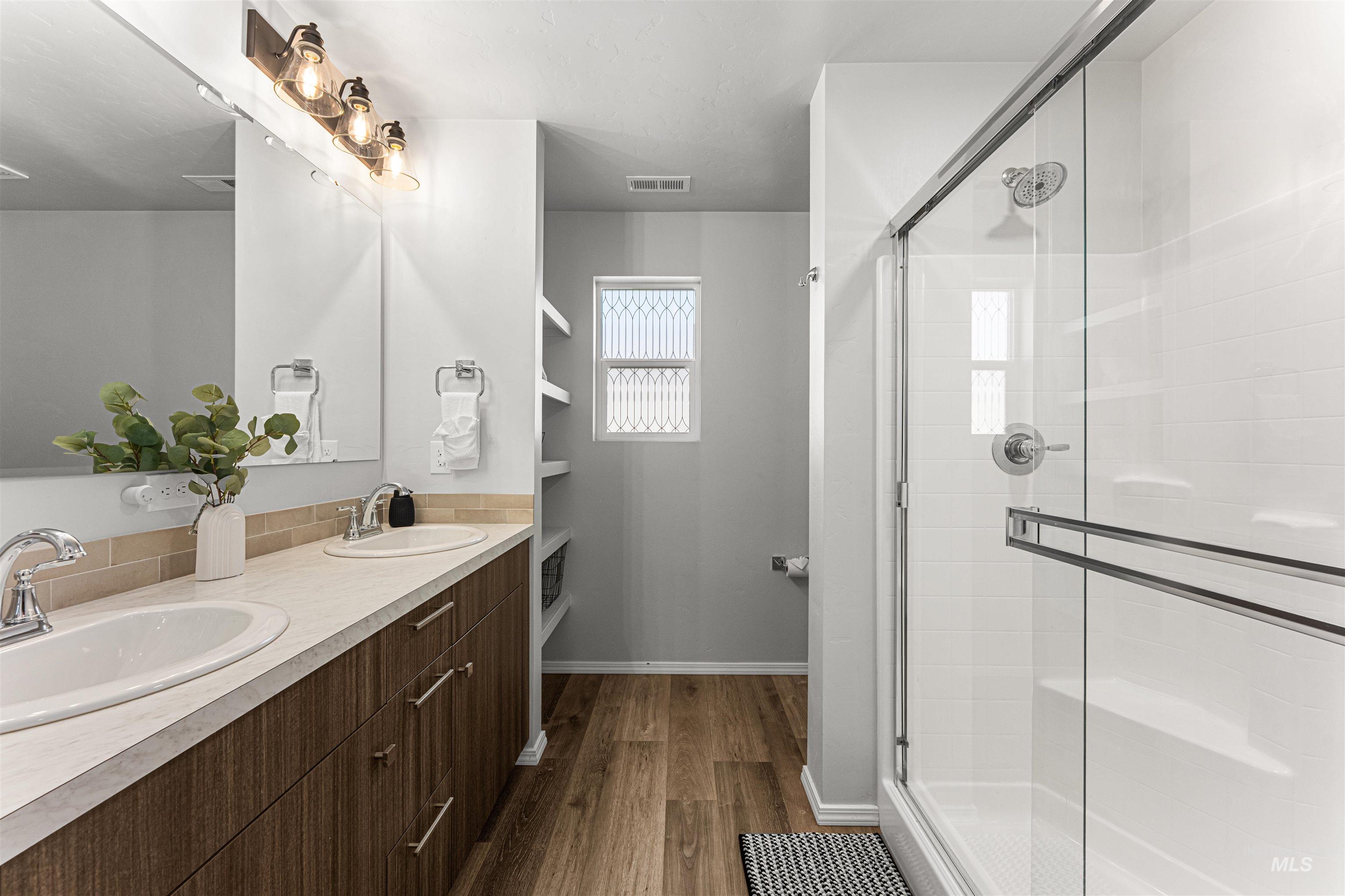 12342 Noreen Street Caldwell, ID 83607 - Photo 28 of 42 Bathroom featuring dark wood-style floors, a stall shower, and double vanity