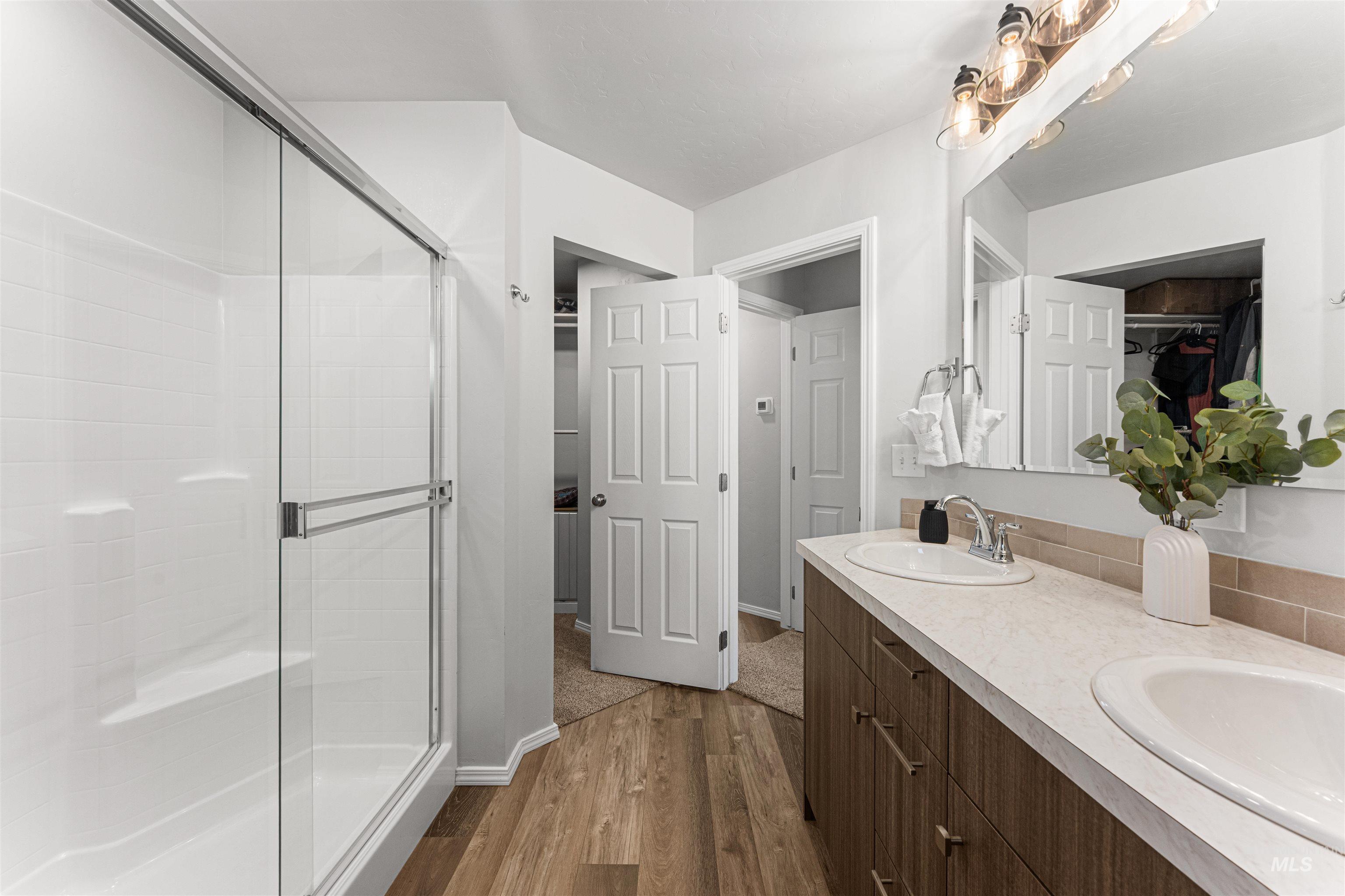 12342 Noreen Street Caldwell, ID 83607 - Photo 29 of 42 Bathroom with double vanity, dark wood-style flooring, and a stall shower