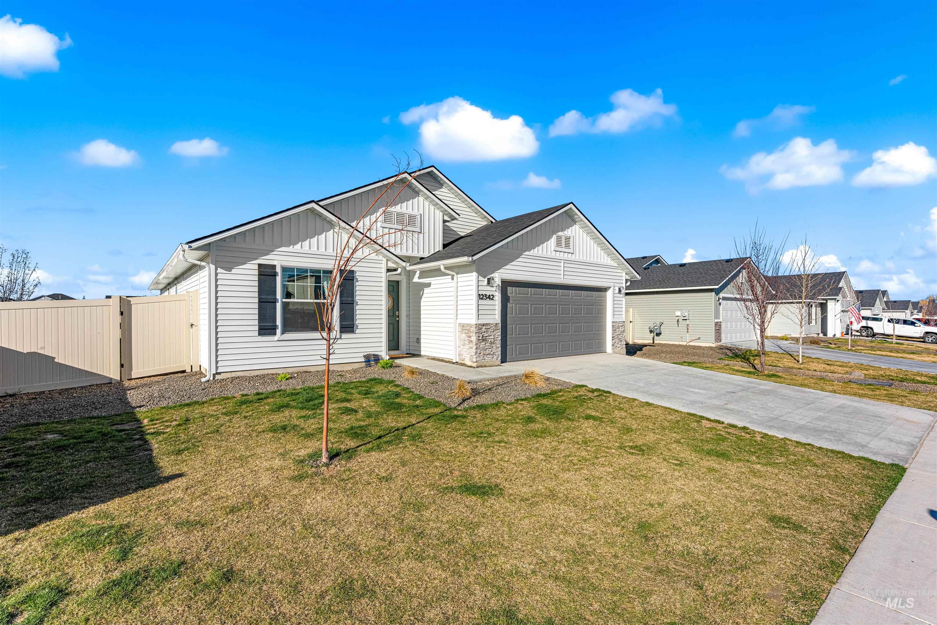 12342 Noreen Street Caldwell, ID 83607 - Photo 4 of 42 View of front of house with a gate, driveway, board and batten siding, and an attached garage