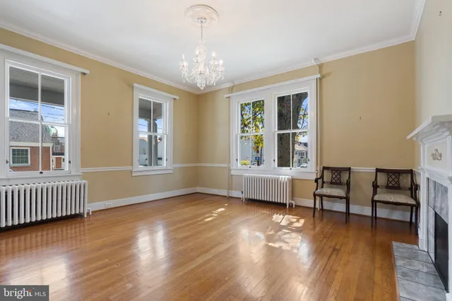 a view of an empty room with window and wooden floor