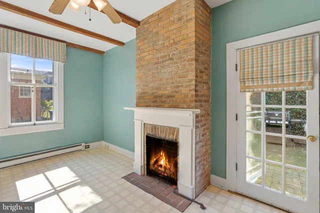 a view of a livingroom with wooden floor and a ceiling fan