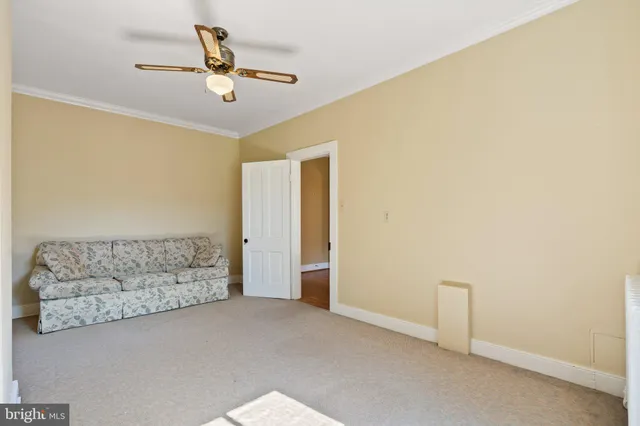 an empty room with wooden floor a ceiling fan and windows