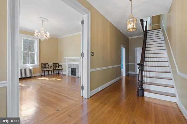 a view of a hallway with wooden floor and staircase
