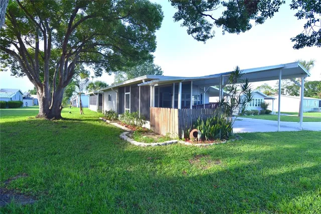 a view of a house with backyard and a tree