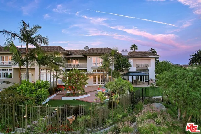 a view of a house with a yard and potted plants