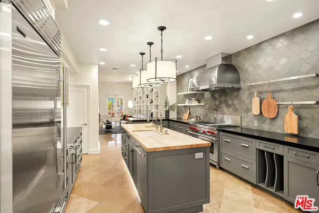 a kitchen with stainless steel appliances granite countertop a sink a stove and a refrigerator