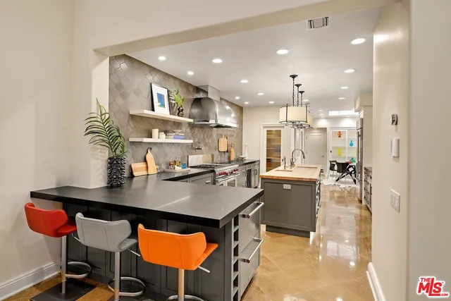 a kitchen with stainless steel appliances granite countertop a refrigerator and a stove top oven