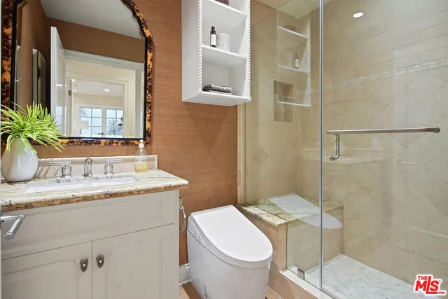 a bathroom with a granite countertop toilet sink and mirror