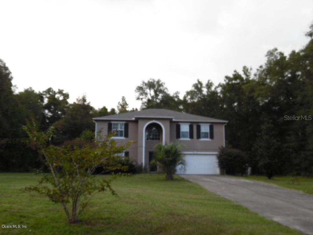 12931 Southwest 66th Street Ocala, FL 34481 - Photo 1 of 1 a front view of a house with a garden