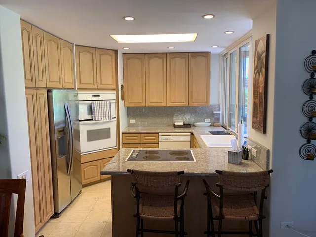a kitchen with a table chairs refrigerator and cabinets