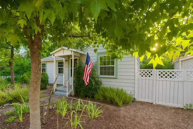a view of a chair and table in backyard of the house