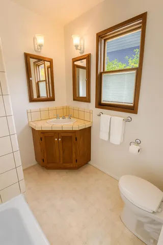 a bathroom with a sink mirror and toilet