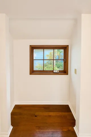 a view of an empty room with wooden floor