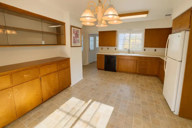 a large kitchen with a refrigerator a sink dishwasher and a stove