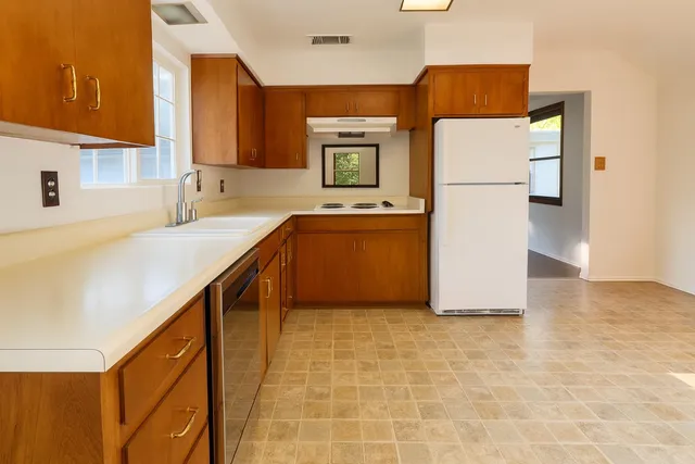 a kitchen with a sink a refrigerator and a stove
