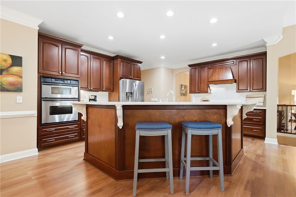 4147 Gold Mill Ridge Canton, GA 30114 - Photo 22 of 93 a kitchen with kitchen island granite countertop wooden cabinets and stainless steel appliances