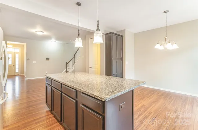 a kitchen with a granite countertop sink and refrigerator