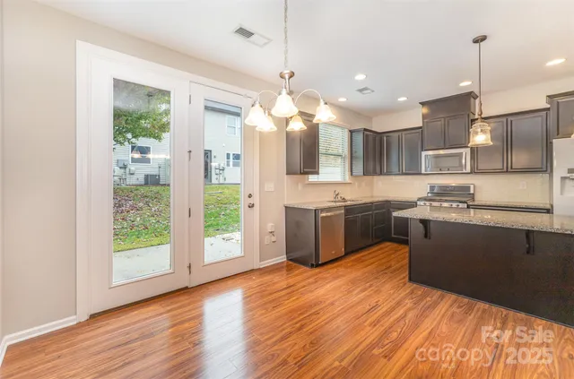 a kitchen with kitchen island a sink stainless steel appliances and cabinets