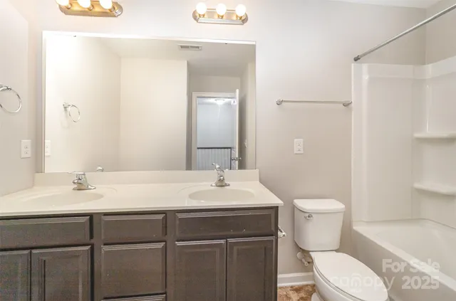 a bathroom with a sink toilet vanity and shower